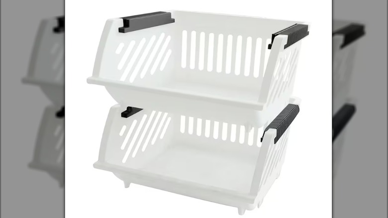 White stackable plastic containers with black handles sit against a white background.