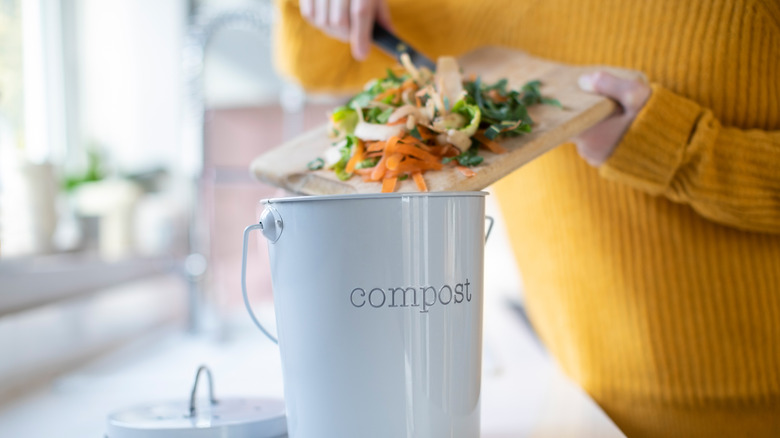 woman scraping scraps into bin