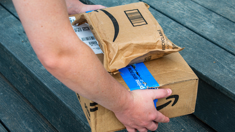 Person picking up Amazon Prime delivery boxes