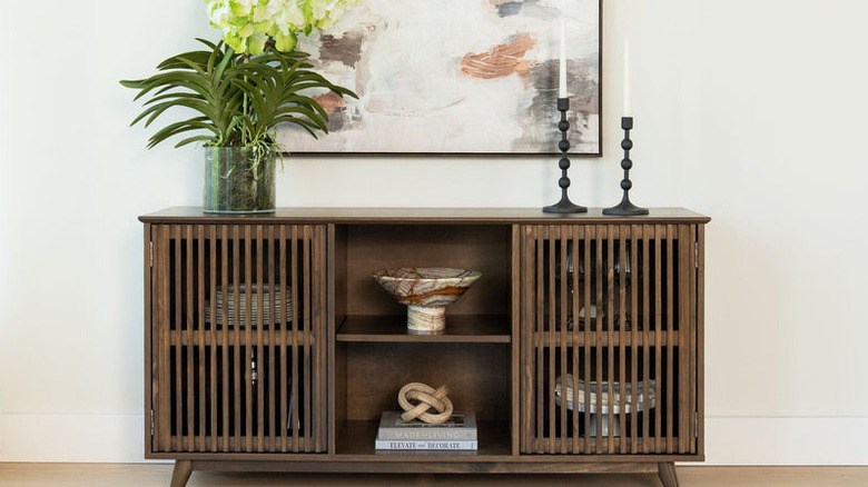 A modern sideboard from Plank & Board against a wall full of decorations and trinkets.