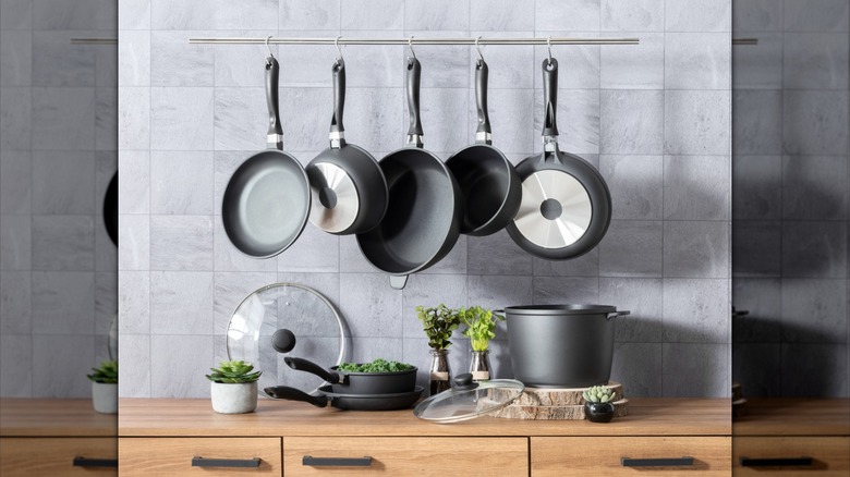 pots and pans suspended from a bar using s-hooks in a modern kitchen