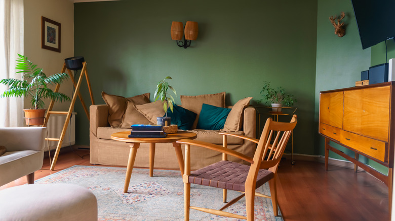 dark and vibrant earthy color palette in retro-inspired living room with blondewood  taper-leg table and chair