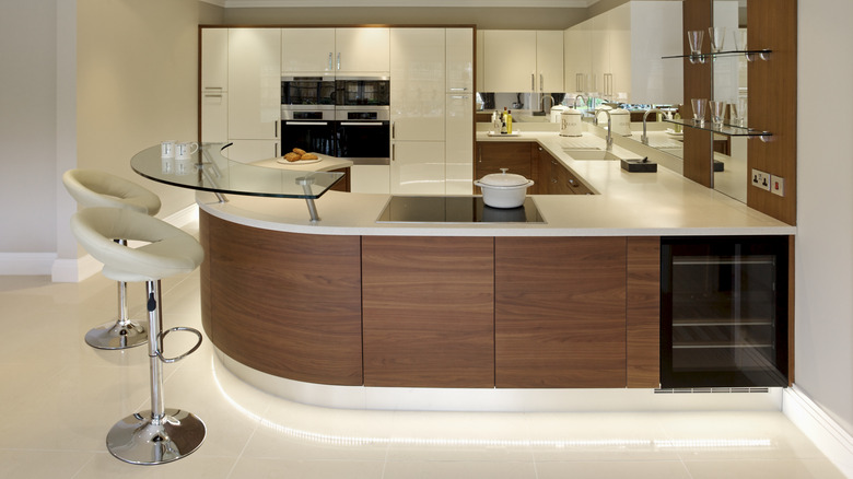 A modern kitchen with white cabinets and walnut features