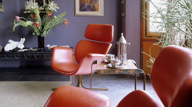 A 1960s modernist interior with leather chairs.