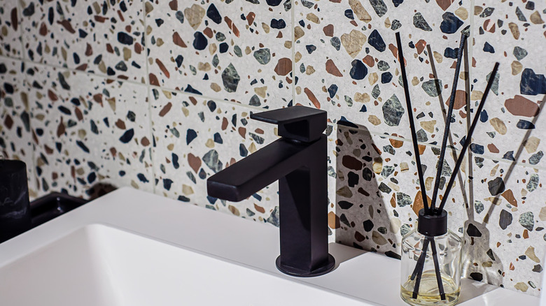 A bathroom with a terrazzo tile backsplash.