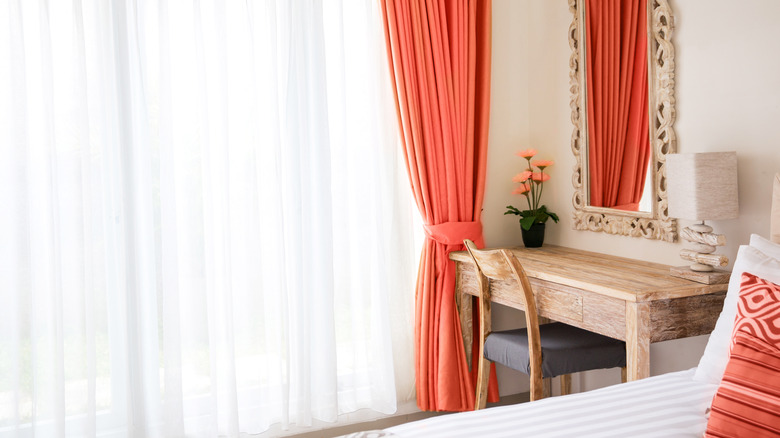 Bedroom with beige walls and coral curtains
