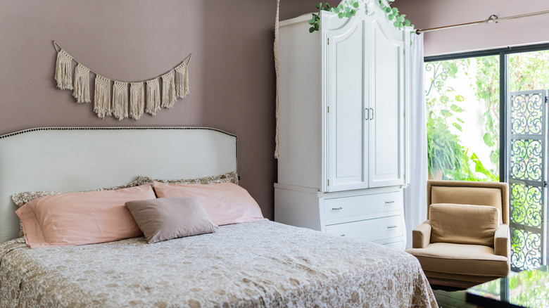 Bedroom with light purple walls and beige and white decor elements
