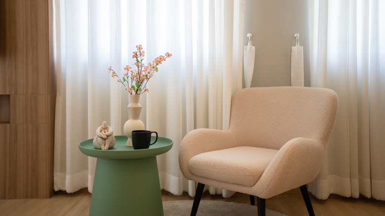 Cozy nook with pistachio side table and boucle armchair
