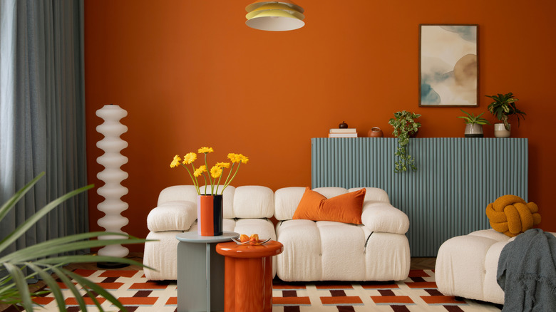Modern living room with '70s elements featuring orange paint and geometric shapes and patterns.