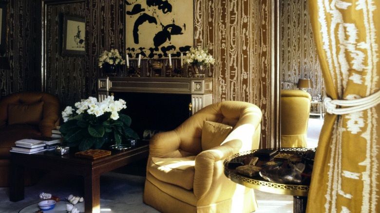 '70s style home with yellow oversized seating and bold patterned wallpaper.