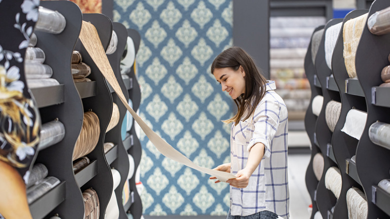 A person shopping for wallpaper in a store