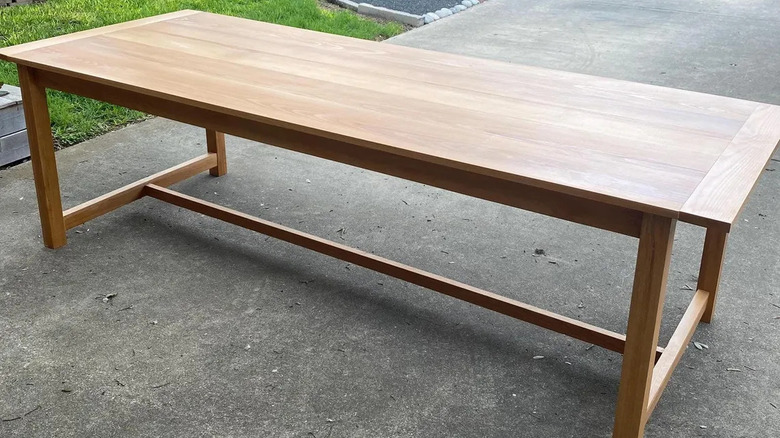 Handmade birch dining table photographed on a concrete patio
