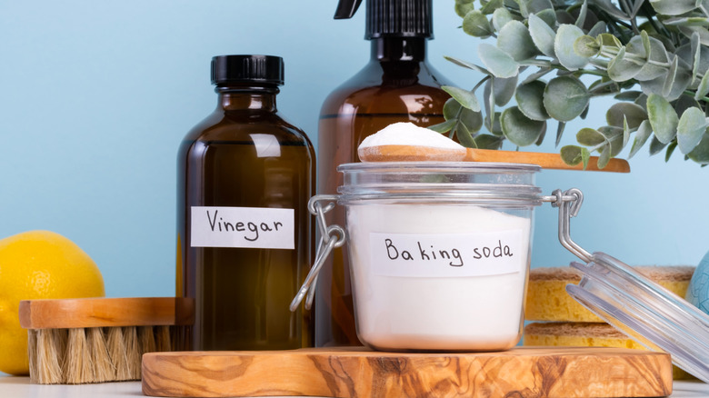 Baking soda and vinegar in glass containers with natural cleaning tools