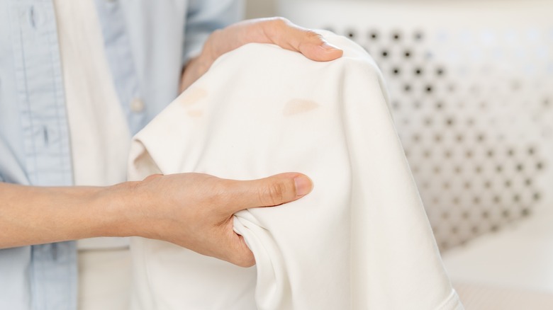 Person holding rust stained clothing