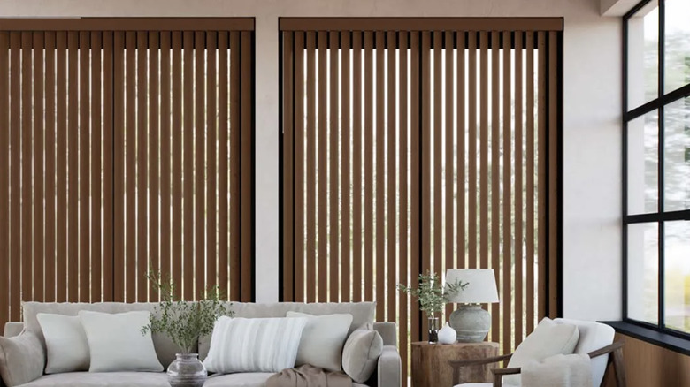 A living room space with sliding glass doors obscured by faux wood blinds