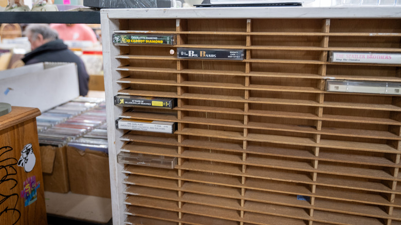 A wooden cassette rack in a vintage store