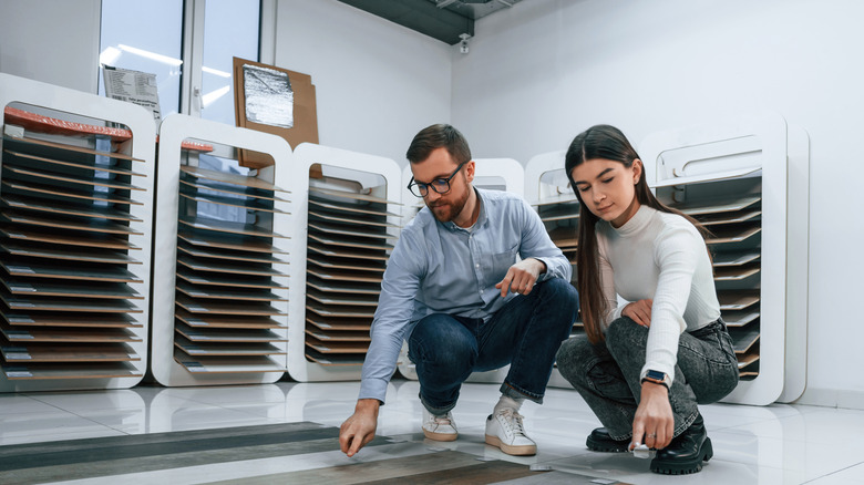 Man and woman looking at flooring samples in a store