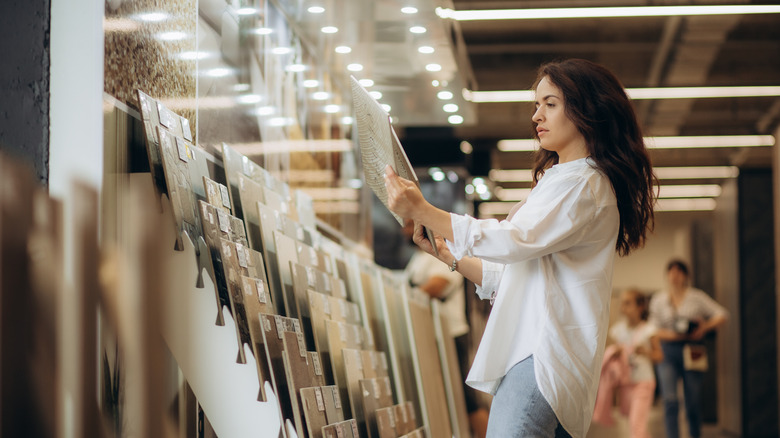 A woman looking at tile samples in a store