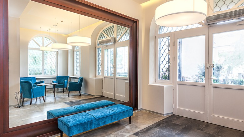 A mirrored wall in a foyer brightens the space.