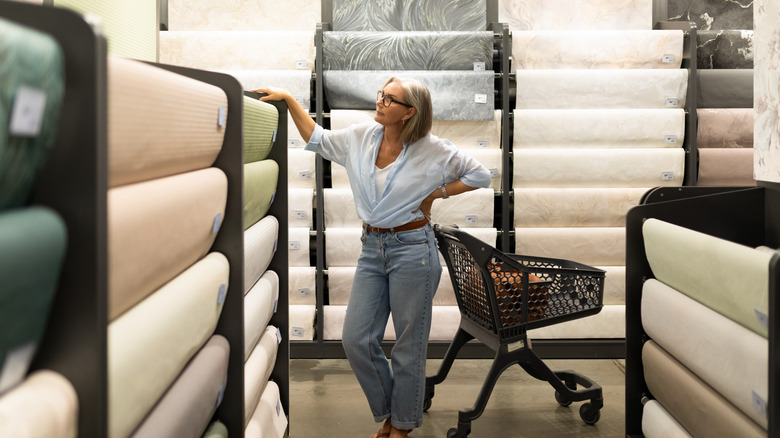 Woman looking at wallpaper samples in store.