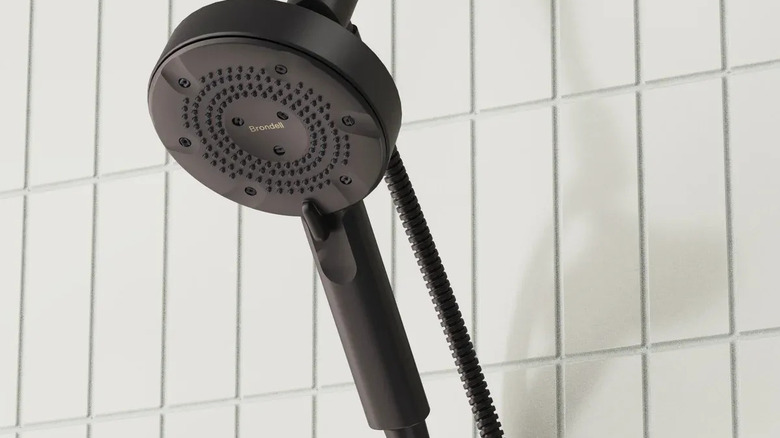 The black Brondell Nebia Merritt 5-setting Handheld Shower Head in a tiled shower