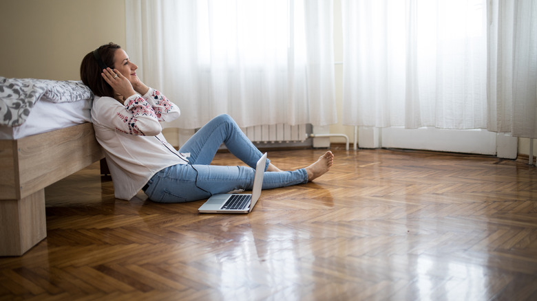 woman lounging on wooden bedroom floor