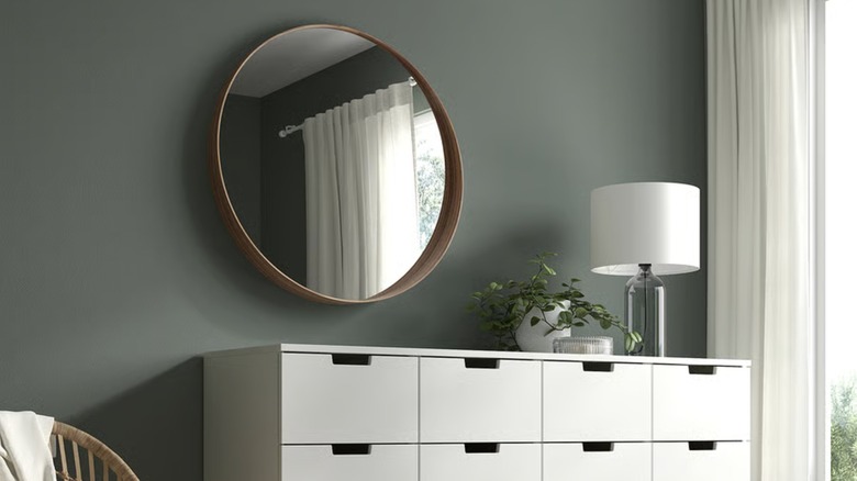 A large walnut veneer mirror from IKEA hangs above a modern dresser