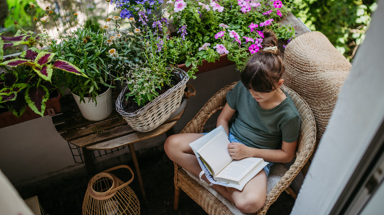 Person reading on a balcony with flowers