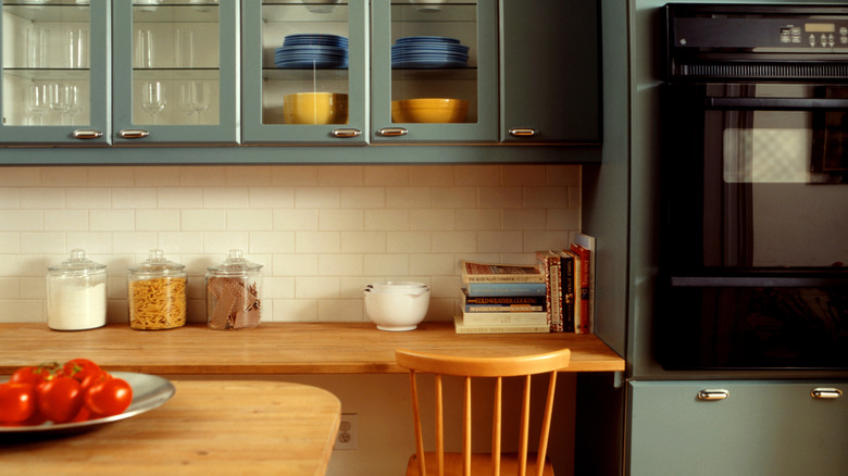A modern-looking kitchen with built-in desk and wooden chair.