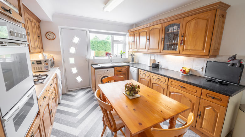 A light-filled eat-in kitchen features wood cabinets