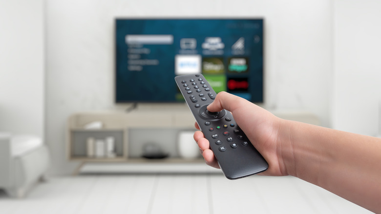 Hand holding remote control for a smart TV