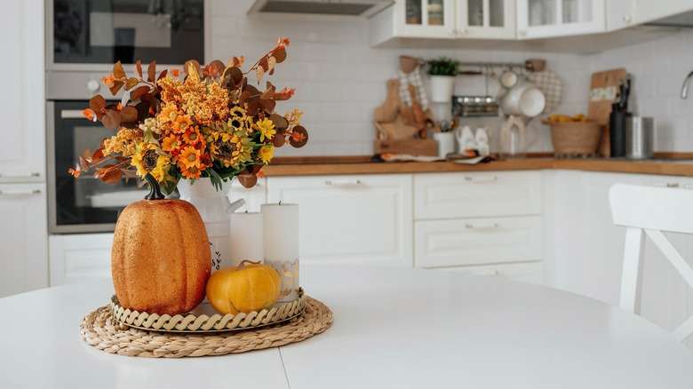 Fall styled kitchen in white with pumpkins and flowers