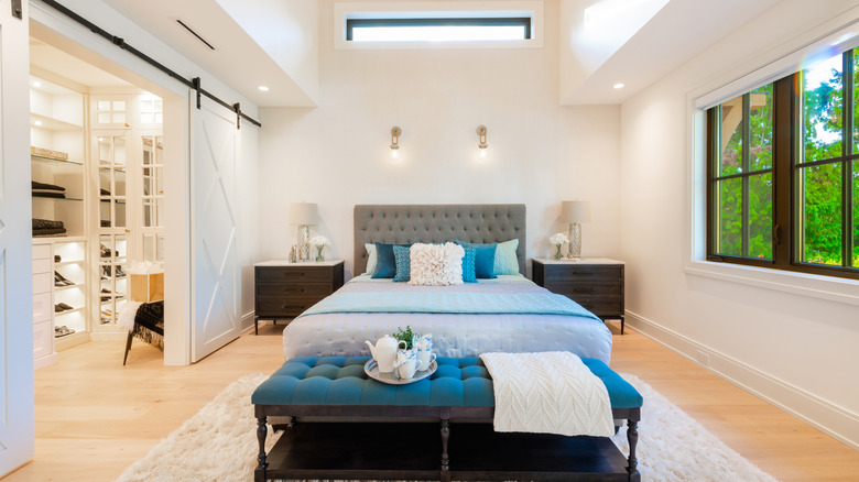 A clean and crisp bedroom with an open walk-in closet on the left.