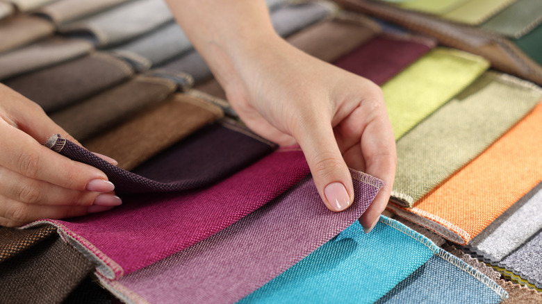 A person looking at upholstery fabric samples