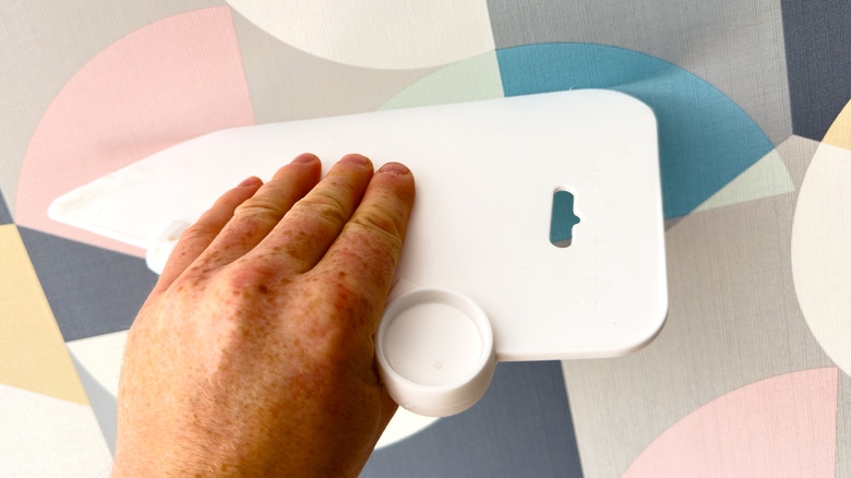 hand smoothing patterned wallpaper