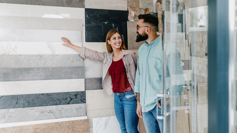 A couple looking at samples of bathroom tiles in a showroom