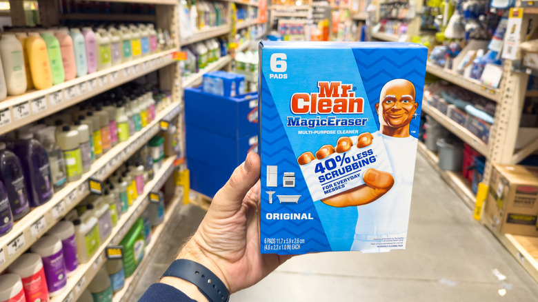 A person holds a Mr. Clean MagicEraser in the aisle of a supermarket.