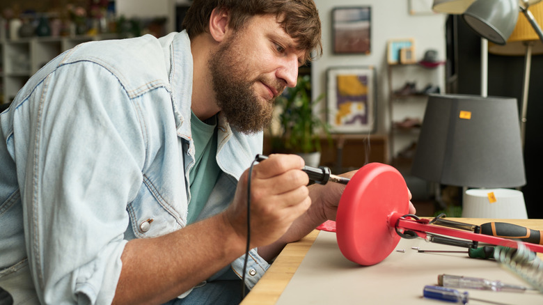 man working on red lamp DIY