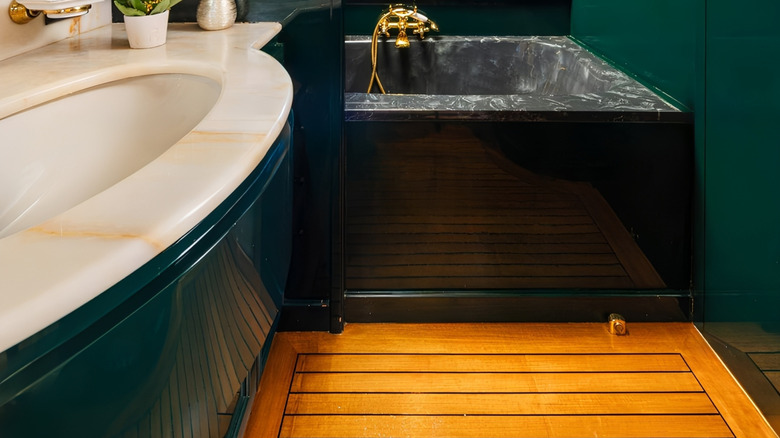 A luxe bathroom with teak flooring.