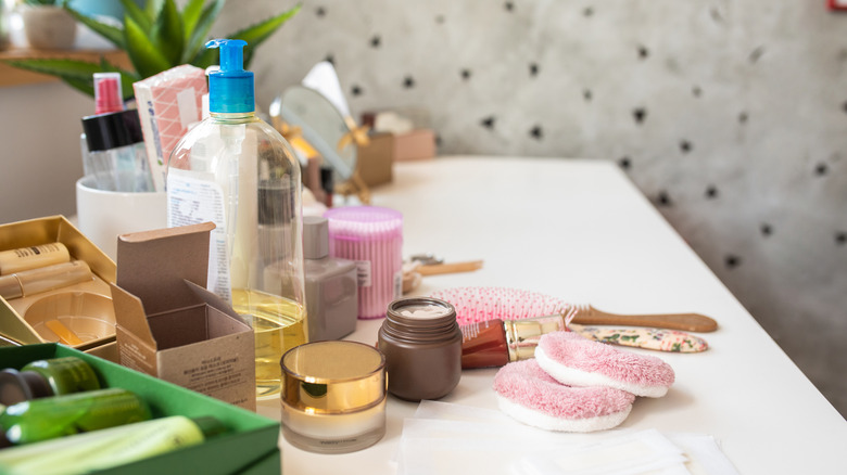A collection of beauty and bath products cluttering a counter