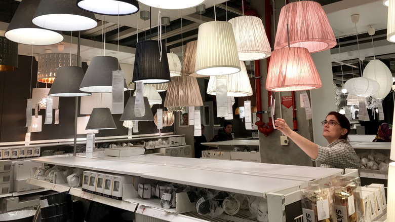 Woman shopping in the lamp section of an IKEA showroom