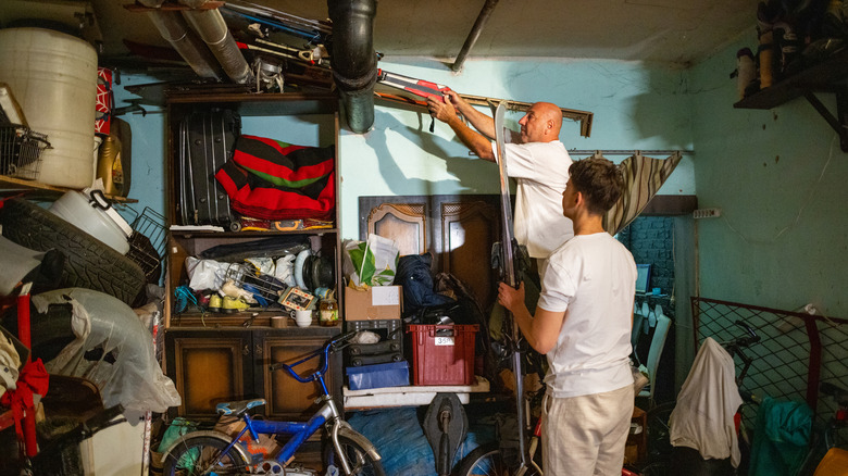 Two men organizing a cluttered garage