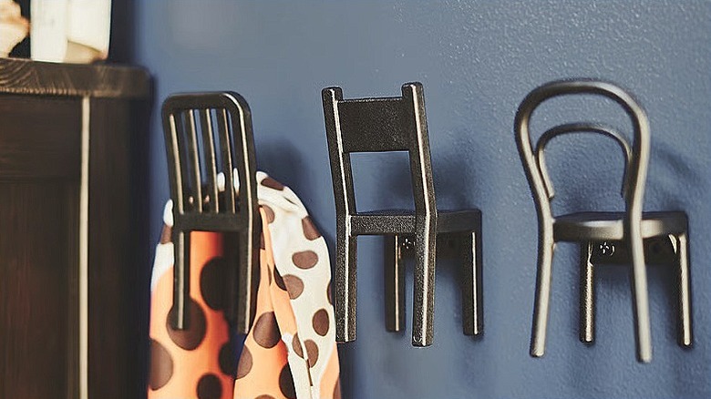 Three IKEA FJANTIG chair hooks attached to a wall with a scarf draped over the first one in the row.