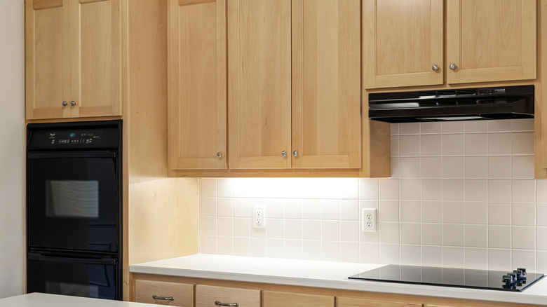 Wooden kitchen cabinets with accessories on top