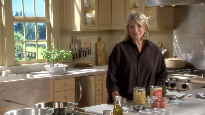 Martha Stewart in a kitchen with light wood cabinets and pantry staples