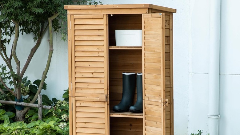 A rustic wooden outdoor closet in a garden