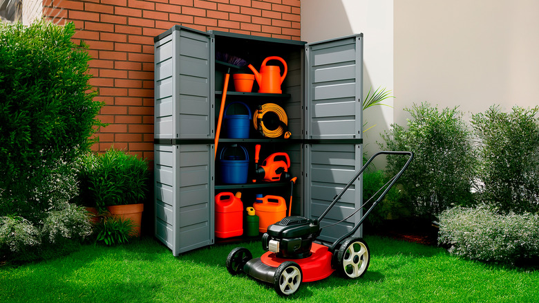 An open outdoor storage cabinet filled with garden equipment