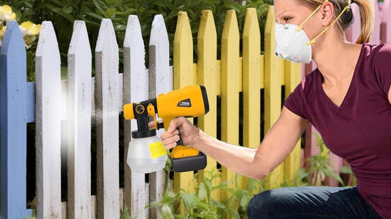 The DtezTech paint sprayer being used for painting a garden fence