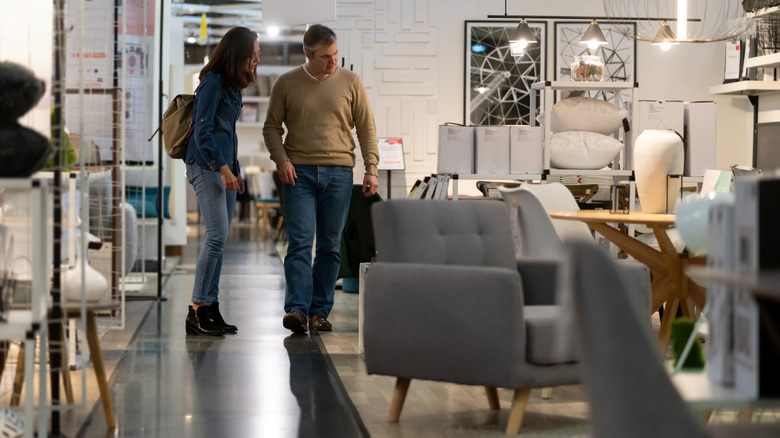 A man and woman looking at furniture in a store