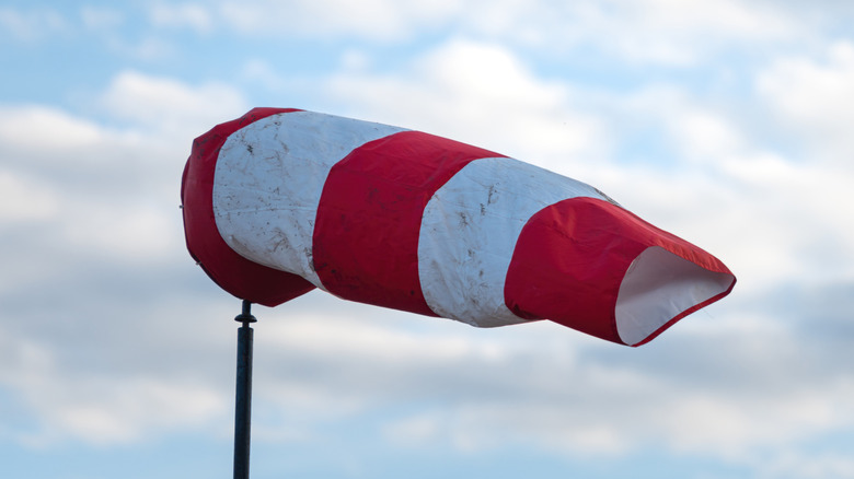 A windsock made of fabric with large red and white stripes.